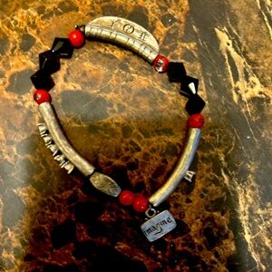 Silver tone bracelet featuring red beads